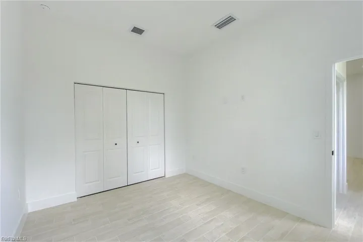 Unfurnished bedroom featuring light wood-style flooring and a closet