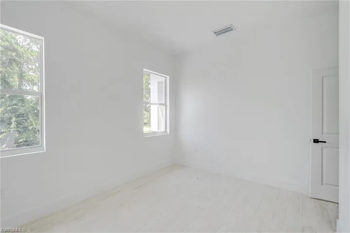 Empty room featuring baseboards and light wood-type flooring