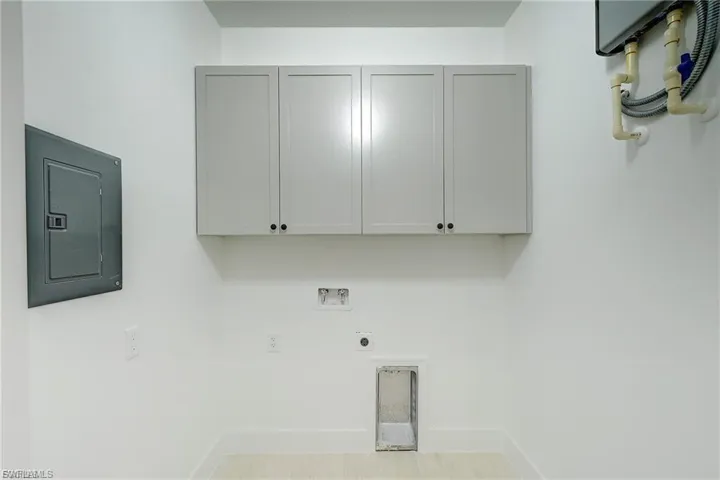 Laundry room featuring electric panel, cabinet space, hookup for a washing machine, and electric dryer hookup