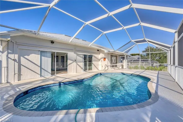 View of swimming pool featuring a sunroom, a lanai, and a patio area