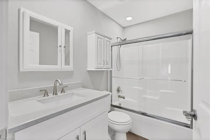 Bathroom with combined bath / shower with glass door and vanity