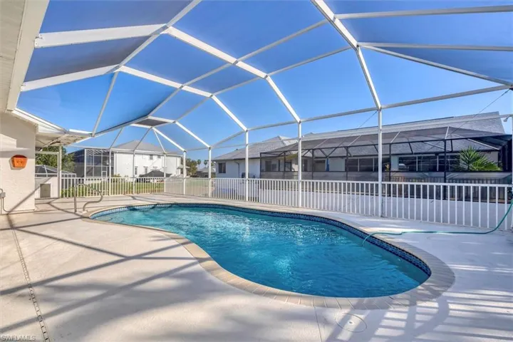 Swimming pool with glass enclosure, a sunroom, and a patio area