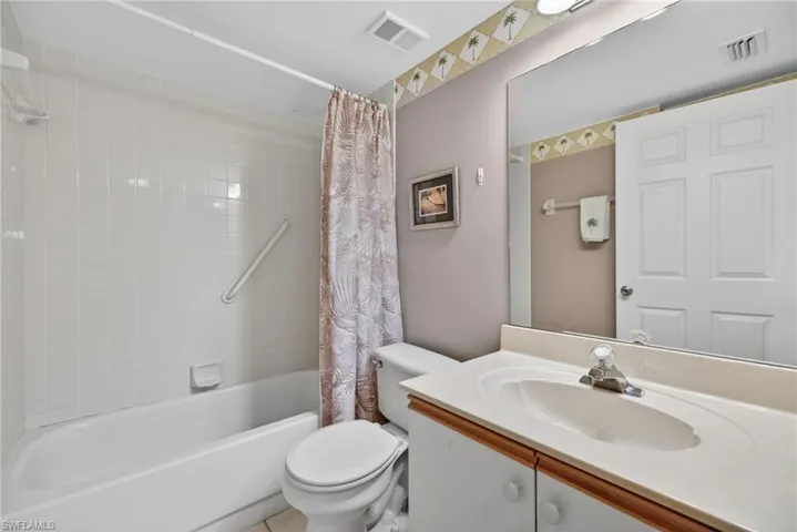 Bathroom featuring shower / bathtub combination with curtain and vanity