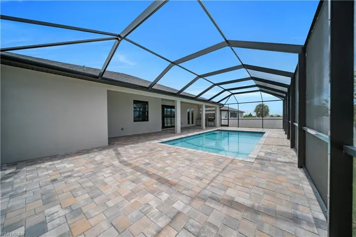 Swimming pool with a sunroom, a patio, and a lanai