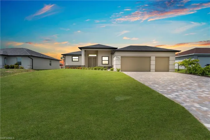 Prairie-style house featuring a front lawn, a garage, and decorative driveway