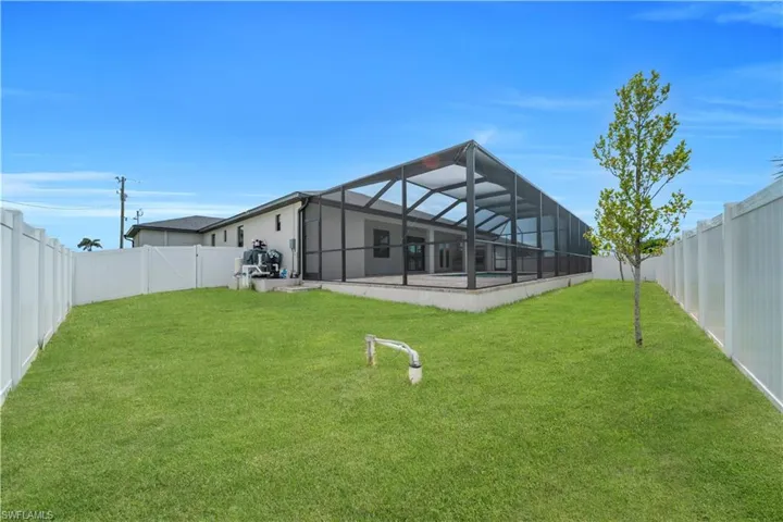 Back of house featuring a sunroom, a lanai, and a fenced backyard