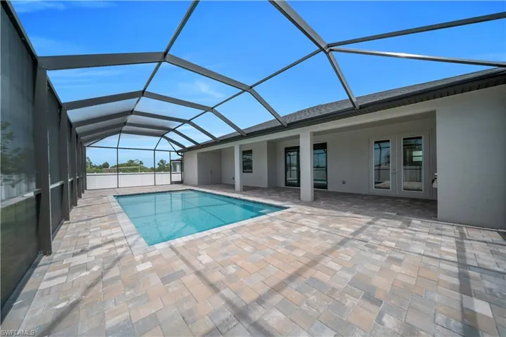 Outdoor pool featuring a sunroom, a lanai, a patio, and french doors