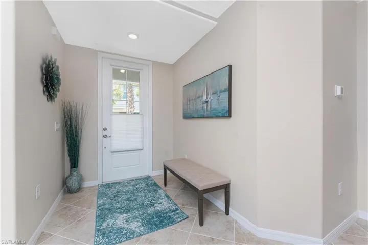 Doorway with baseboards and tile patterned flooring