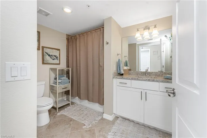 Full bathroom featuring vanity, a shower with curtain, light tile patterned floors, and recessed lighting