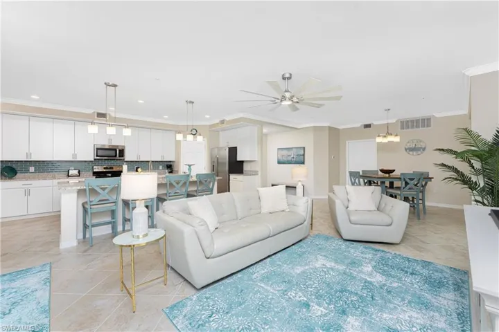 Living area featuring crown molding, ceiling fan, light tile patterned floors, and recessed lighting