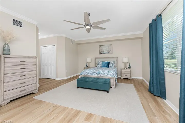 Bedroom featuring crown molding, light wood finished floors, and ceiling fan