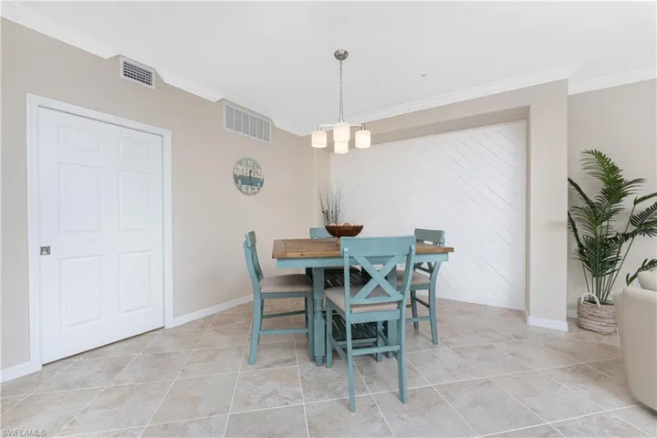 Dining space featuring ornamental molding and light tile patterned floors