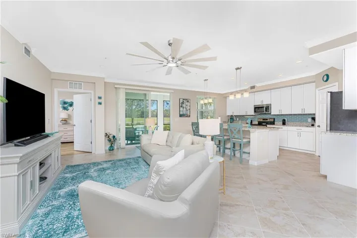 Living room with crown molding, ceiling fan, recessed lighting, and light tile patterned flooring