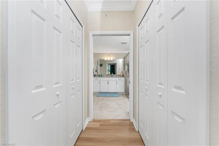 Corridor featuring crown molding and light wood finished floors