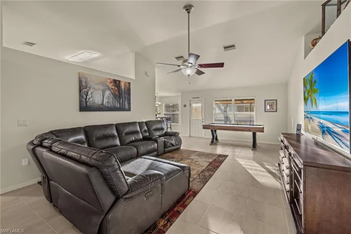 Tiled living room featuring ceiling fan, Cathedral Ceiling