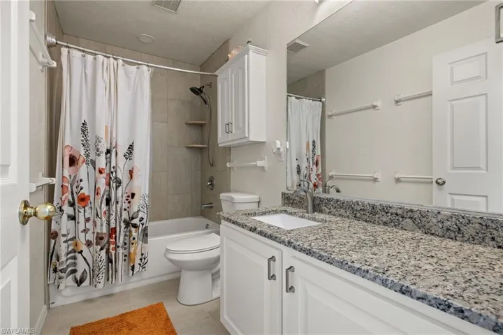 Full bathroom with combination tub & shower with ceramic tiles and granite counter tops.
