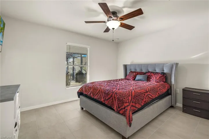 West Bedroom with ceiling fan and view of pool