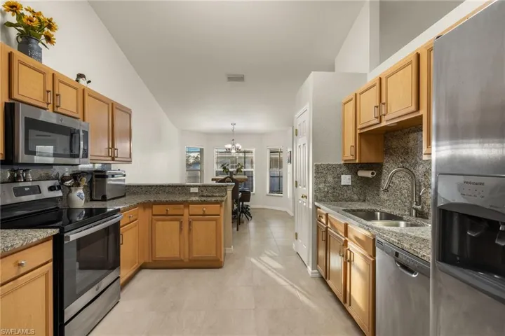 Kitchen with soft close cabinets, granite counter tops & backsplash, stainless steel appliances