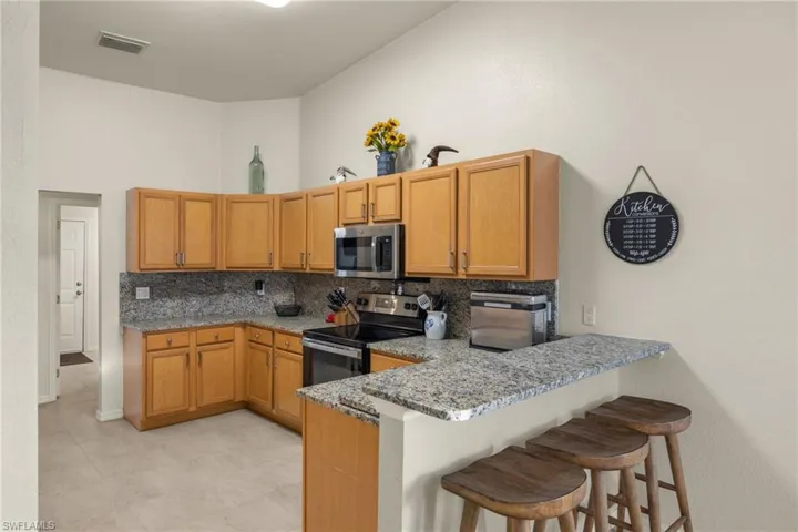 Kitchen with granite counter tops & backsplash, stainless steel appliances