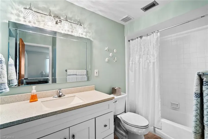 Full bathroom featuring toilet, large vanity, and shower / bath combo