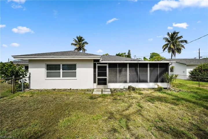 Back of property with a sunroom and a yard