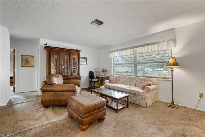 Carpeted living room with a textured ceiling