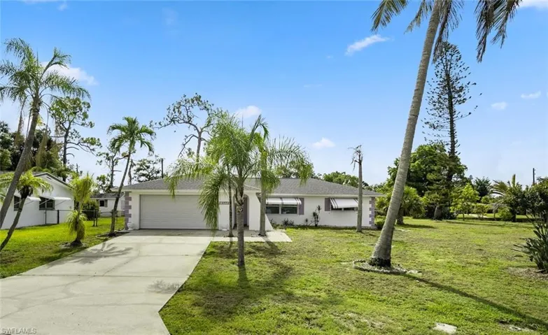 Ranch-style home with a front lawn and a garage