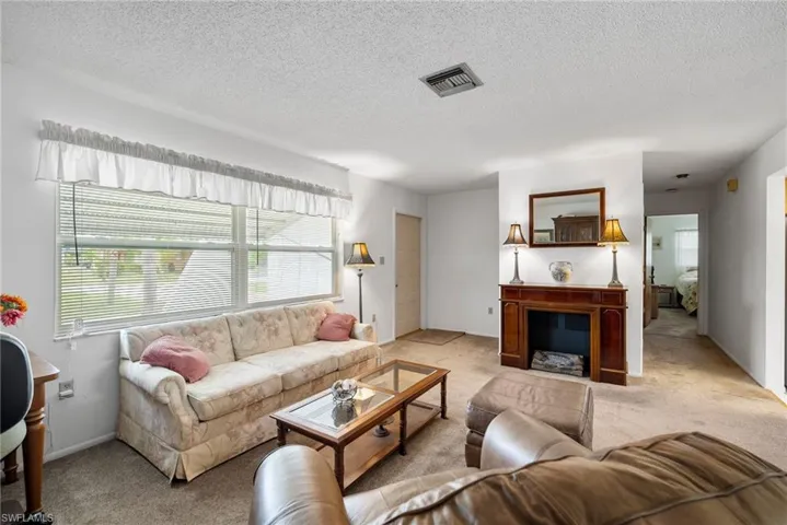 Living room with carpet and a textured ceiling