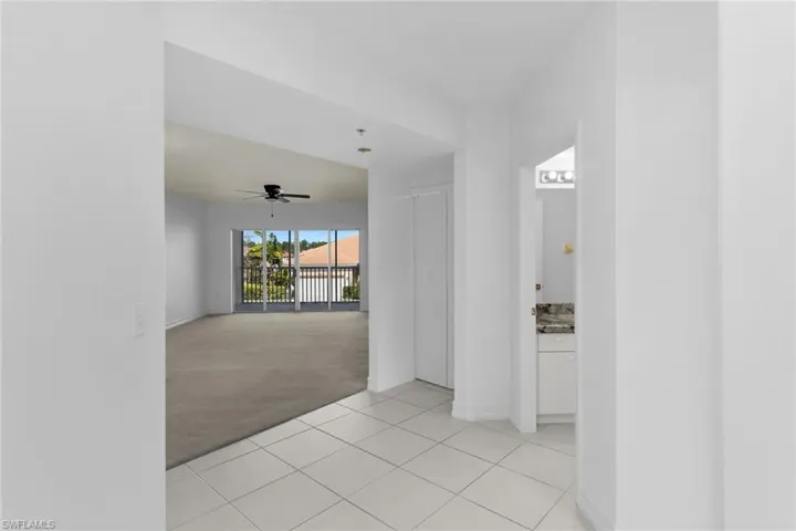 Corridor featuring light colored carpet and light tile patterned flooring