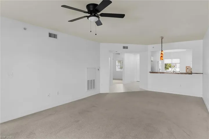 Unfurnished living room featuring light colored carpet and ceiling fan