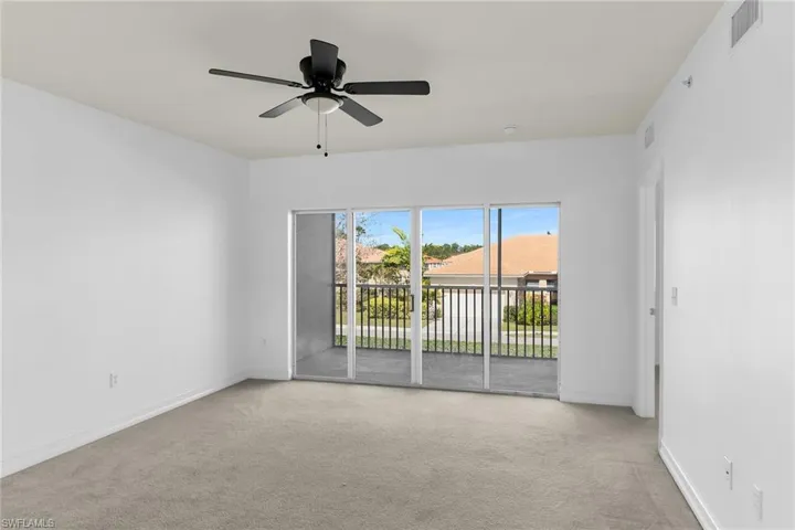 Spare room featuring light colored carpet and ceiling fan