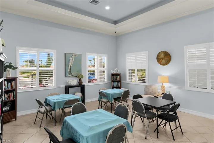 Dining space with light tile patterned floors, ornamental molding, and a raised ceiling