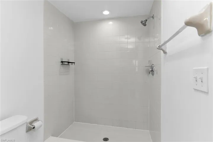 Full bathroom featuring toilet and a stall shower