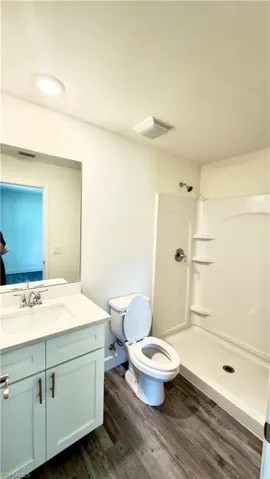 Bathroom featuring a white vanity with a single sink, light-colored countertop, and modern cabinet hardware