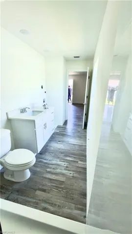 Bathroom featuring a single vanity with white cabinetry, a built-in sink, and a white countertop