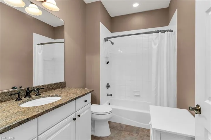 Full bathroom featuring tile patterned floors, vanity, toilet, and shower / bath combo