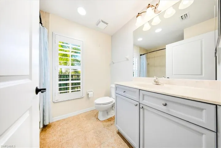 Full bathroom with vanity, a shower with shower curtain, and light tile patterned flooring