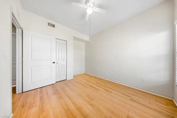 Unfurnished bedroom featuring light wood-style floors, a ceiling fan, and a closet