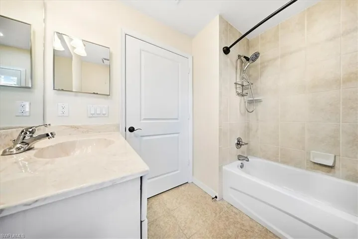 Full bathroom featuring bathtub / shower combination, vanity, and light tile patterned flooring