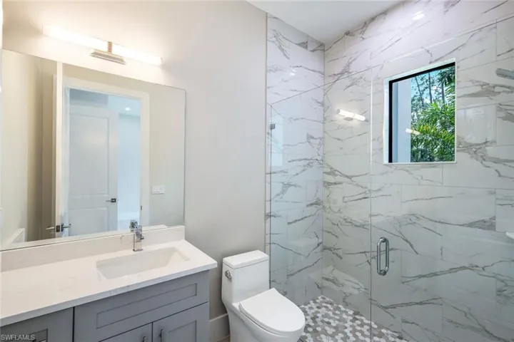 Bathroom with walk in shower, toilet, and vanity