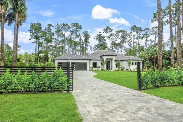 View of front of property with a garage and a front yard
