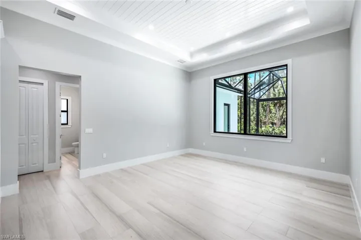 Unfurnished room featuring a raised ceiling and light hardwood / wood-style floors