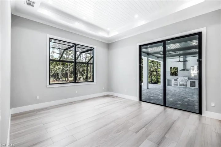 Empty room with light hardwood / wood-style floors and a tray ceiling