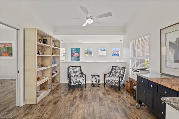 Sitting room featuring dark wood-style flooring and ceiling fan