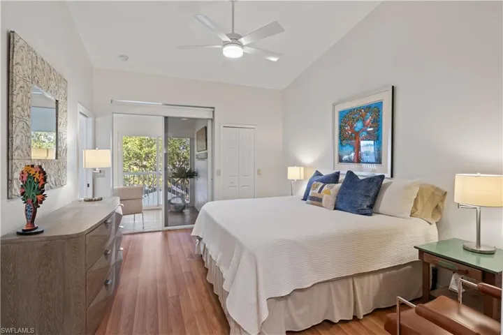 Bedroom featuring light wood-style floors, access to exterior, ceiling fan, a closet, and high vaulted ceiling
