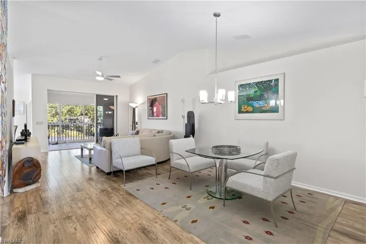Dining area featuring wood finished floors, ceiling fan, and high vaulted ceiling