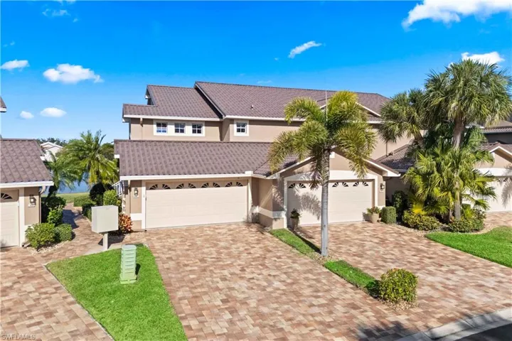 Traditional-style house with stucco siding, a garage, decorative driveway, and a tiled roof