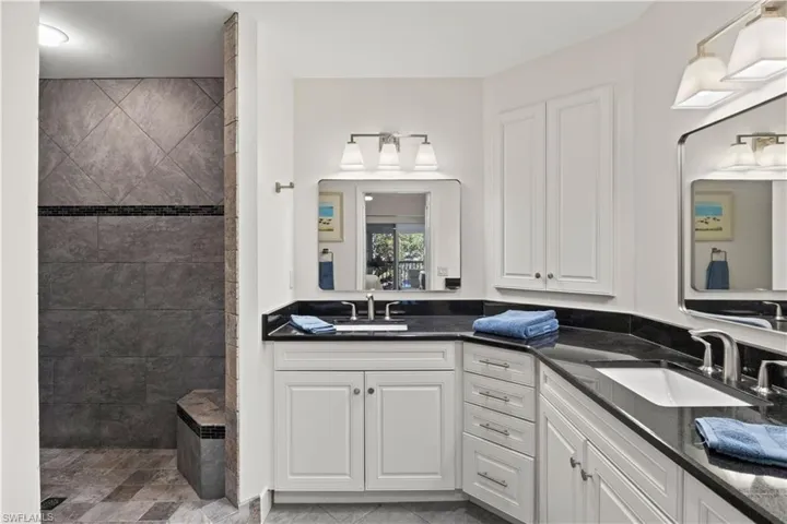 Full bathroom featuring double vanity and a tile shower