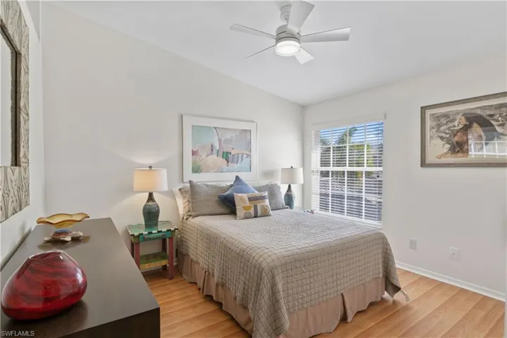 Bedroom with light wood-type flooring, ceiling fan, and lofted ceiling