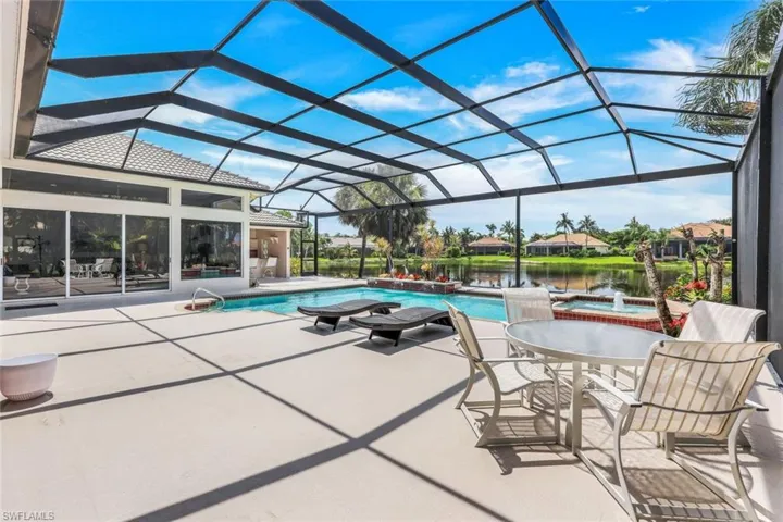 View of swimming pool with a hot tub, a patio, and a lanai